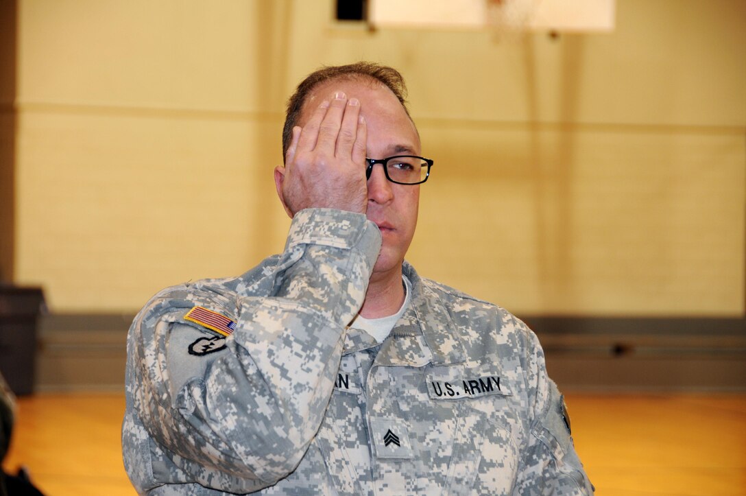 Sgt. Thomas Tallman, a water treatment specialist from North Lake, Illinois assigned to the U.S. Army Reserve’s 318th Press Camp Headquarters, reads an eye chart during a mass medical event Nov. 4. at Muscatatuck Urban Training Center, Indiana.  Mass medical events are designed to help local unit commanders who want to increase their medical readiness in a short amount of time.