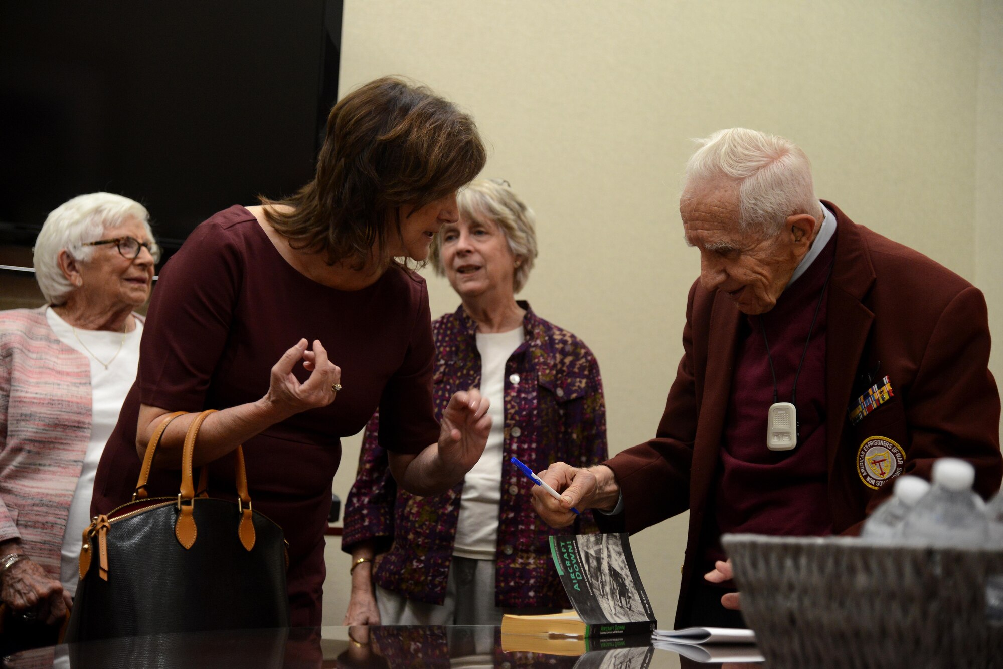 Sonny Fassoulis, right, signs a copy of the book “Aircraft Down,” a book about John Caraberis and the crew that was shot down over Italy in 1943, at MacDill Air Force Base, Fla., Nov. 4, 2016. Fassoulis, the navigator on the flight that was shot down, came out to honor Caraberis, who was posthumously awarded the Silver Star Medal.