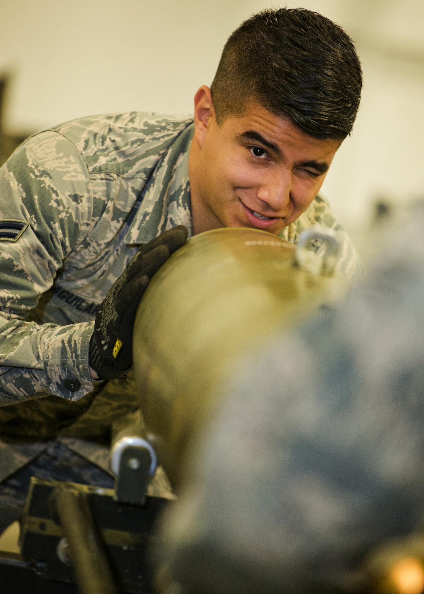 Airman 1st Class Mario Aguilar, 5th Munitions Squadron line delivery crew chief, looks through a tab on an inert GBU-38 at Minot Air Force Base, N.D., Oct. 27, 2016. During bomb assemblies, tabs are used to assist Airmen with correctly aligning the nose aero-surface on the inert 500 lb. MK82 bomb. (U.S. Air Force photo/Airman 1st Class J.T. Armstrong)