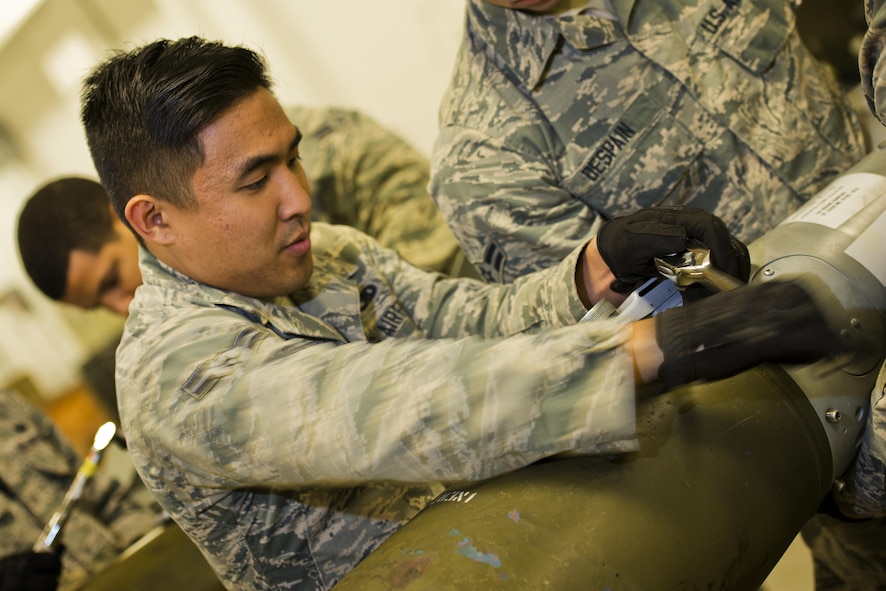 Airman 1st Class Joseph Lee, 5th Munitions Squadron line delivery crew chief, tightens screws on a GBU-38 tail assembly at Minot Air Force Base, N.D., Oct. 27, 2016. During bomb building, screws are tightened to secure the tail guidance kit on an inert 500 lb. MK82 bomb. (U.S. Air Force photo/Airman 1st Class J.T. Armstrong)