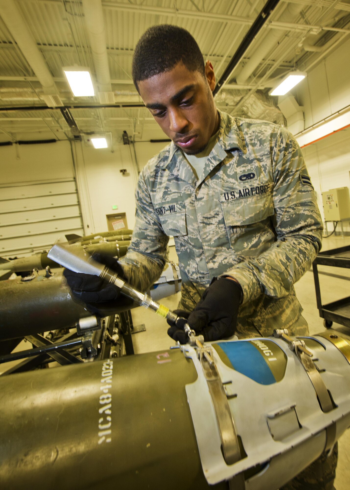Airman 1st Class Ginseler Saint-Vil, 5th Munitions Squadron line delivery technician, tightens screws on a GBU-38 nose aero-surface assembly at Minot Air Force Base, N.D., Oct. 27, 2016. During bomb building, set screws are tightened to secure the nose aero-surface assembly on an inert 500 lb. MK82 bomb. (U.S. Air Force photo/Airman 1st Class J.T. Armstrong)