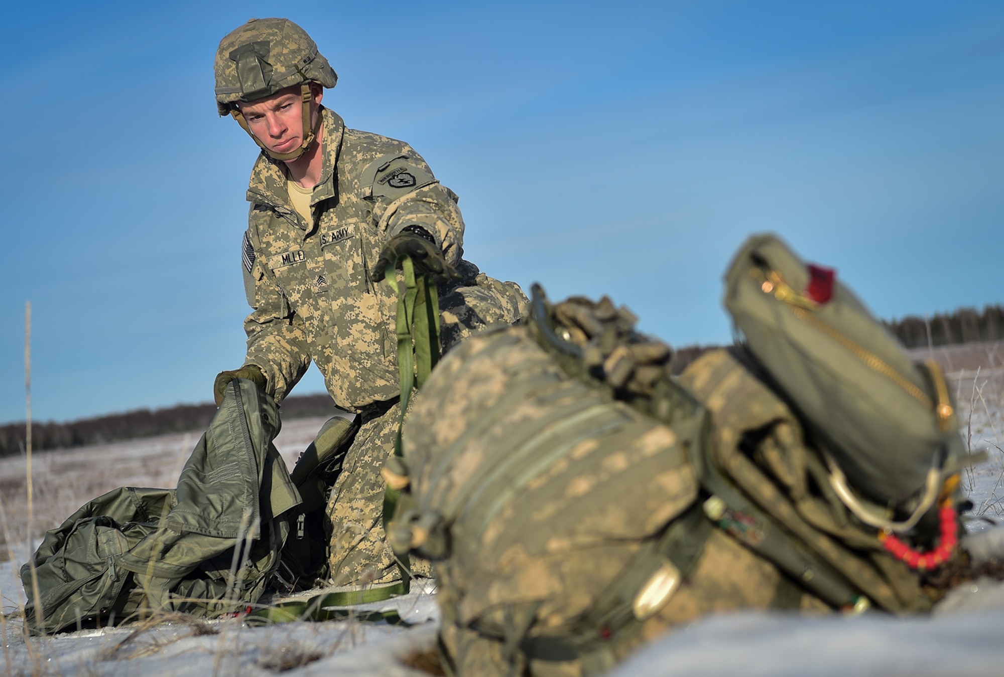U.S. Army Sgt. Shane Miller, a native of Mission Viejo, Calif., assigned to Charlie Troop, 1st Squadron (Airborne), 40th Cavalry Regiment, 4th Infantry Brigade Combat Team (Airborne), 25th Infantry Division, U.S. Army Alaska, gathers his equipment after executing an airborne training jump from a CH-47 Chinook helicopter on Malemute drop zone at Joint Base Elmendorf-Richardson, Alaska, Thursday, Nov. 3, 2016. The Soldiers of 4/25 IBCT belong to the only American airborne brigade in the Pacific and are trained to execute airborne maneuvers in extreme cold weather/high altitude environments in support of combat, partnership and disaster relief operations. 