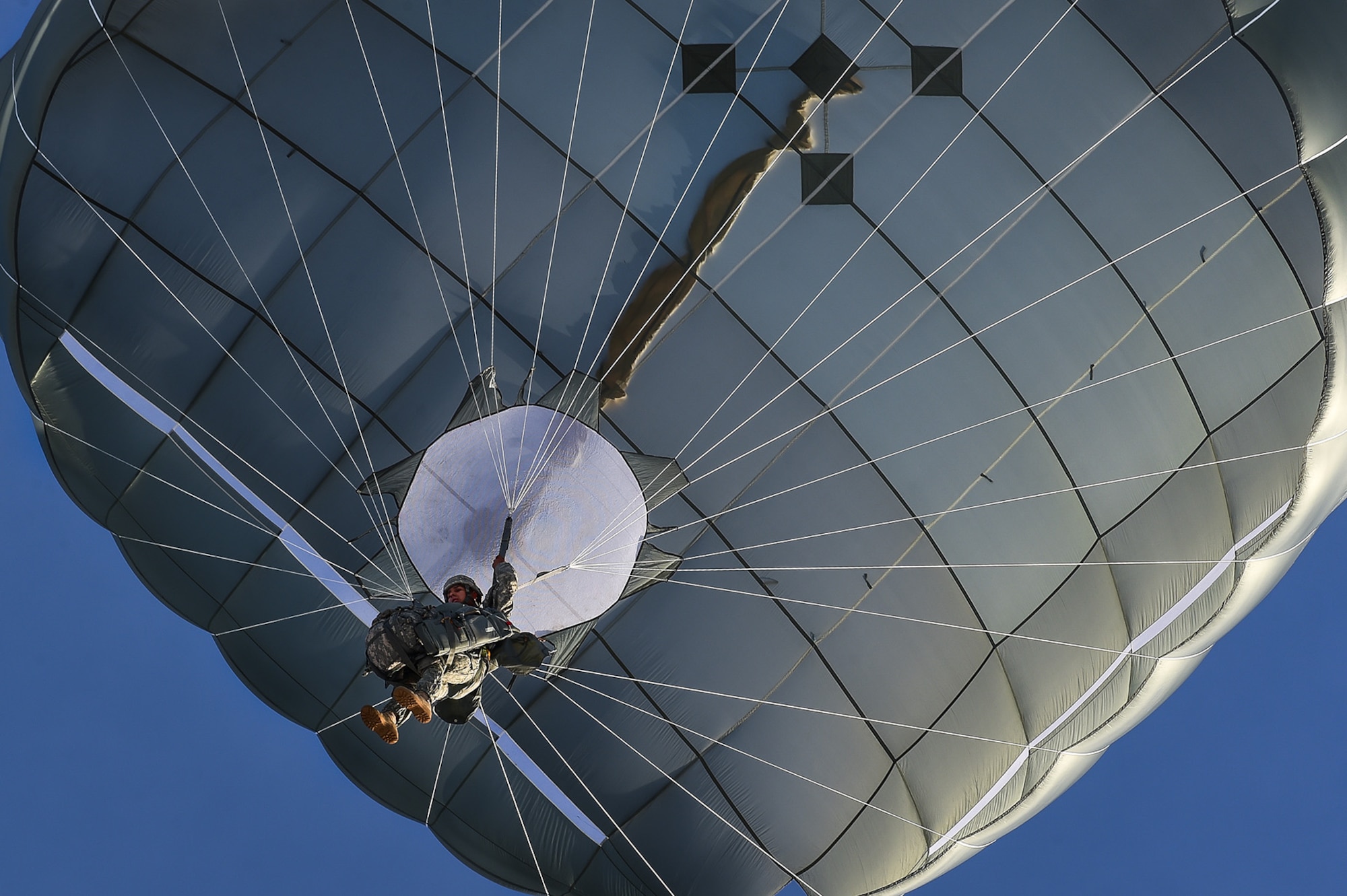 A U.S. Army paratrooper assigned to the 4th Infantry Brigade Combat Team (Airborne), 25th Infantry Division, U.S. Army Alaska, descends under a full canopy during an airborne training jump from a CH-47 Chinook helicopter on Malemute drop zone at Joint Base Elmendorf-Richardson, Alaska, Thursday, Nov. 3, 2016. The Soldiers of 4/25 IBCT belong to the only American airborne brigade in the Pacific and are trained to execute airborne maneuvers in extreme cold weather/high altitude environments in support of combat, partnership and disaster relief operations. 