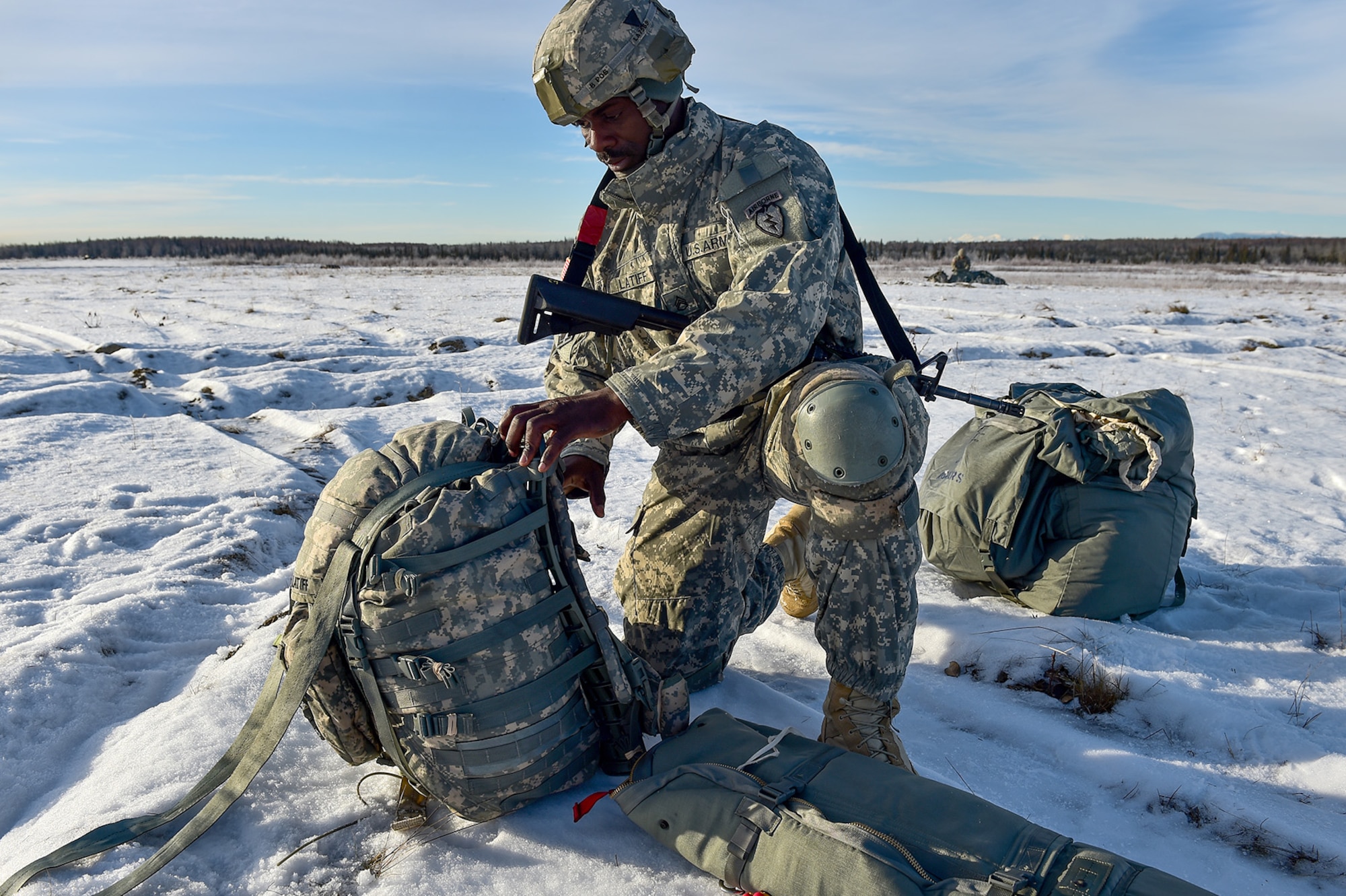 U.S. Army Staff Sgt. Kofi Latiff, a native of Brooklyn, NY, assigned to B Company, 6th Brigade Engineer Battalion (Airborne), 4th Infantry Brigade Combat Team (Airborne), 25th Infantry Division, U.S. Army Alaska, secures his rucksack after an airborne training jump from a CH-47 Chinook helicopter on Malemute drop zone at Joint Base Elmendorf-Richardson, Alaska, Thursday, Nov. 3, 2016. The Soldiers of 4/25 IBCT belong to the only American airborne brigade in the Pacific and are trained to execute airborne maneuvers in extreme cold weather/high altitude environments in support of combat, partnership and disaster relief operations.