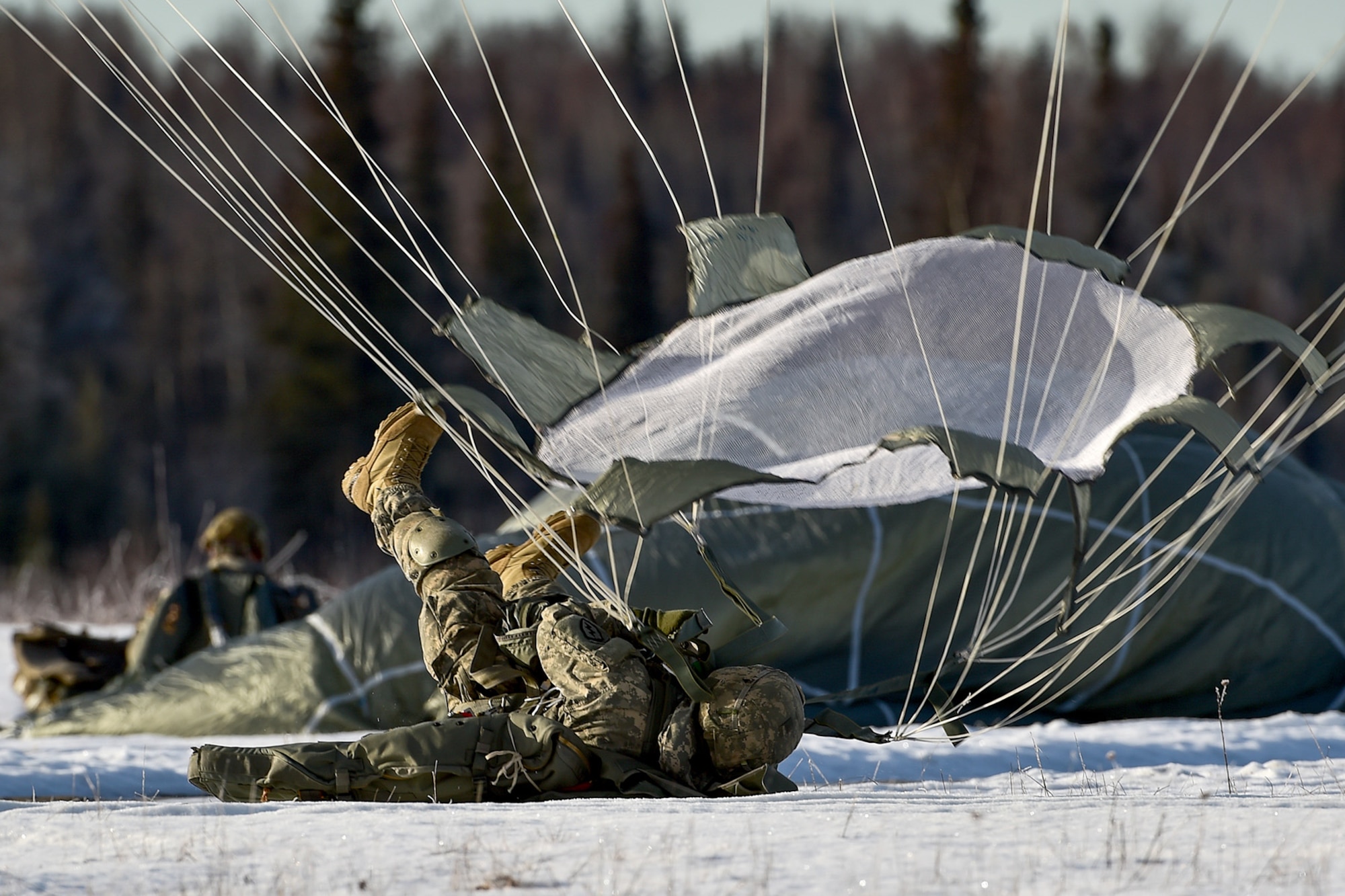 A U.S. Army paratrooper assigned to the 4th Infantry Brigade Combat Team (Airborne), 25th Infantry Division, U.S. Army Alaska, executes a parachute landing fall during an airborne training jump from a CH-47 Chinook helicopter on Malemute drop zone at Joint Base Elmendorf-Richardson, Alaska, Thursday, Nov. 3, 2016. The Soldiers of 4/25 IBCT belong to the only American airborne brigade in the Pacific and are trained to execute airborne maneuvers in extreme cold weather/high altitude environments in support of combat, partnership and disaster relief operations.
