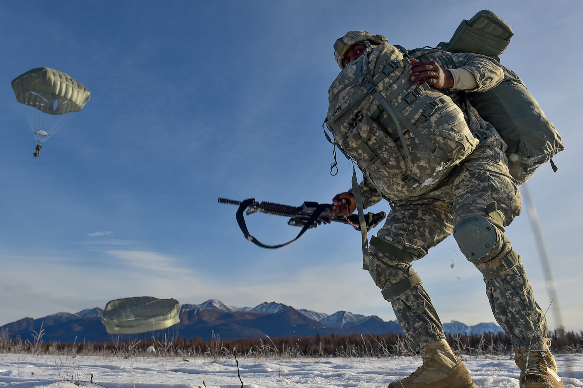 U.S. Army Staff Sgt. Kofi Latiff, a native of Brooklyn, NY, assigned to B Company, 6th Brigade Engineer Battalion (Airborne), 4th Infantry Brigade Combat Team (Airborne), 25th Infantry Division, U.S. Army Alaska, stands up with a loaded rucksack and stowed parachute after an airborne training jump from a CH-47 Chinook helicopter on Malemute drop zone at Joint Base Elmendorf-Richardson, Alaska, Thursday, Nov. 3, 2016. The Soldiers of 4/25 IBCT belong to the only American airborne brigade in the Pacific and are trained to execute airborne maneuvers in extreme cold weather/high altitude environments in support of combat, partnership and disaster relief operations. 