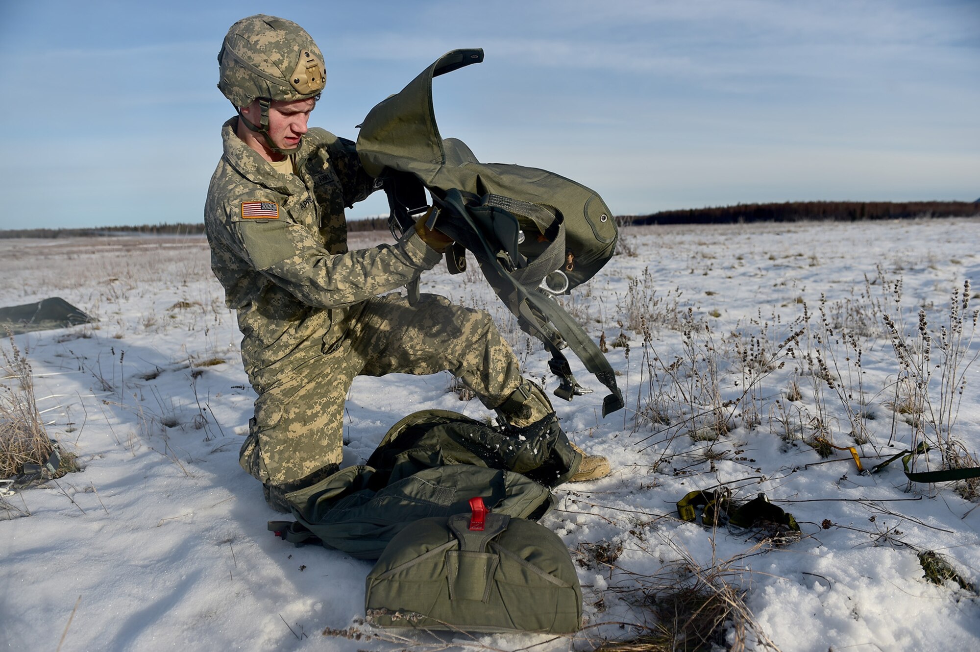 U.S. Army Pfc. Brandon Appel, a native of Bangor, Maine, assigned to Headquarters and Headquarters Company, 725th Brigade Support Battalion (Airborne), 4th Infantry Brigade Combat Team (Airborne), 25th Infantry Division, U.S. Army Alaska, packs up his harness after executing an airborne training jump from a CH-47 Chinook helicopter on Malemute drop zone at Joint Base Elmendorf-Richardson, Alaska, Thursday, Nov. 3, 2016. The Soldiers of 4/25 IBCT belong to the only American airborne brigade in the Pacific and are trained to execute airborne maneuvers in extreme cold weather/high altitude environments in support of combat, partnership and disaster relief operations. 