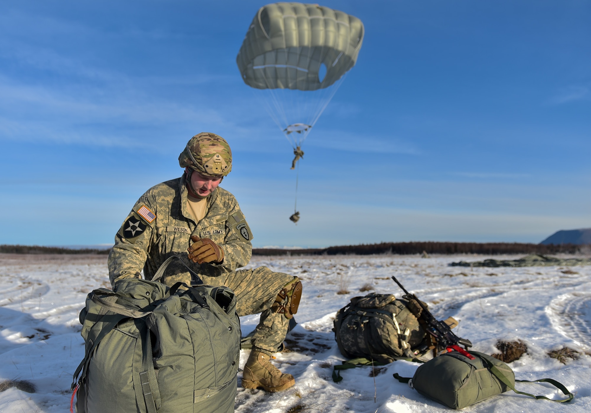 U.S. Army Sgt. Andrew Wilson, a native of Grass Valley, Calif., assigned to the 4th Infantry Brigade Combat Team (Airborne), 25th Infantry Division, U.S. Army Alaska, packs up his parachute after an airborne training jump from a CH-47 Chinook helicopter on Malemute drop zone at Joint Base Elmendorf-Richardson, Alaska, Thursday, Nov. 3, 2016. The Soldiers of 4/25 IBCT belong to the only American airborne brigade in the Pacific and are trained to execute airborne maneuvers in extreme cold weather/high altitude environments in support of combat, partnership and disaster relief operations.