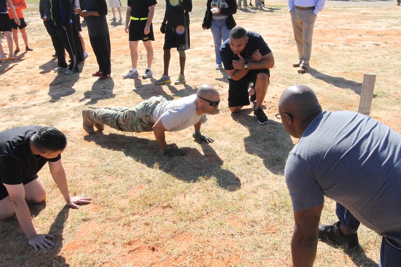 Lt. Col. Derek Johnson (center), aide de camp to the commanding general, U.S. Army Central, participates in the push-up competition during the USARCENT Organization Day, Nov. 4, at the Shaw Air Force Base Fight House. Soldiers participated in a little friendly competition of pushups, pullups, a litter carry, Humvee push race, a USARCENT history quiz, and tug of war. 