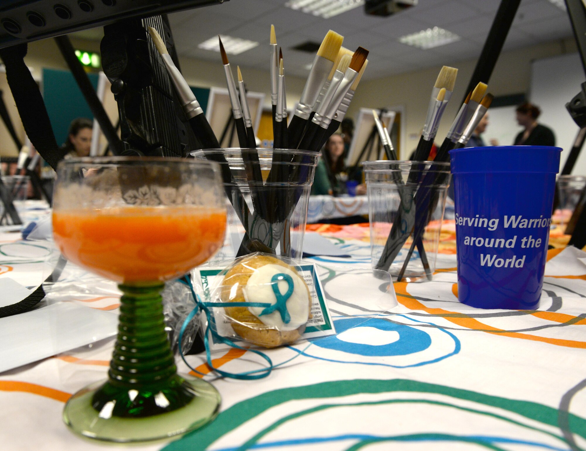 Paint brushed and beverages sit on a table Nov. 4, 2016, during the ‘Breathe, Sip, Paint’ even on RAF Mildenhall, England. The Center for Character and Culture organized the event to promote a stress-free creative environment and teach holistic means of resiliency. (U.S. Air Force photo by Senior Airman Justine Rho)