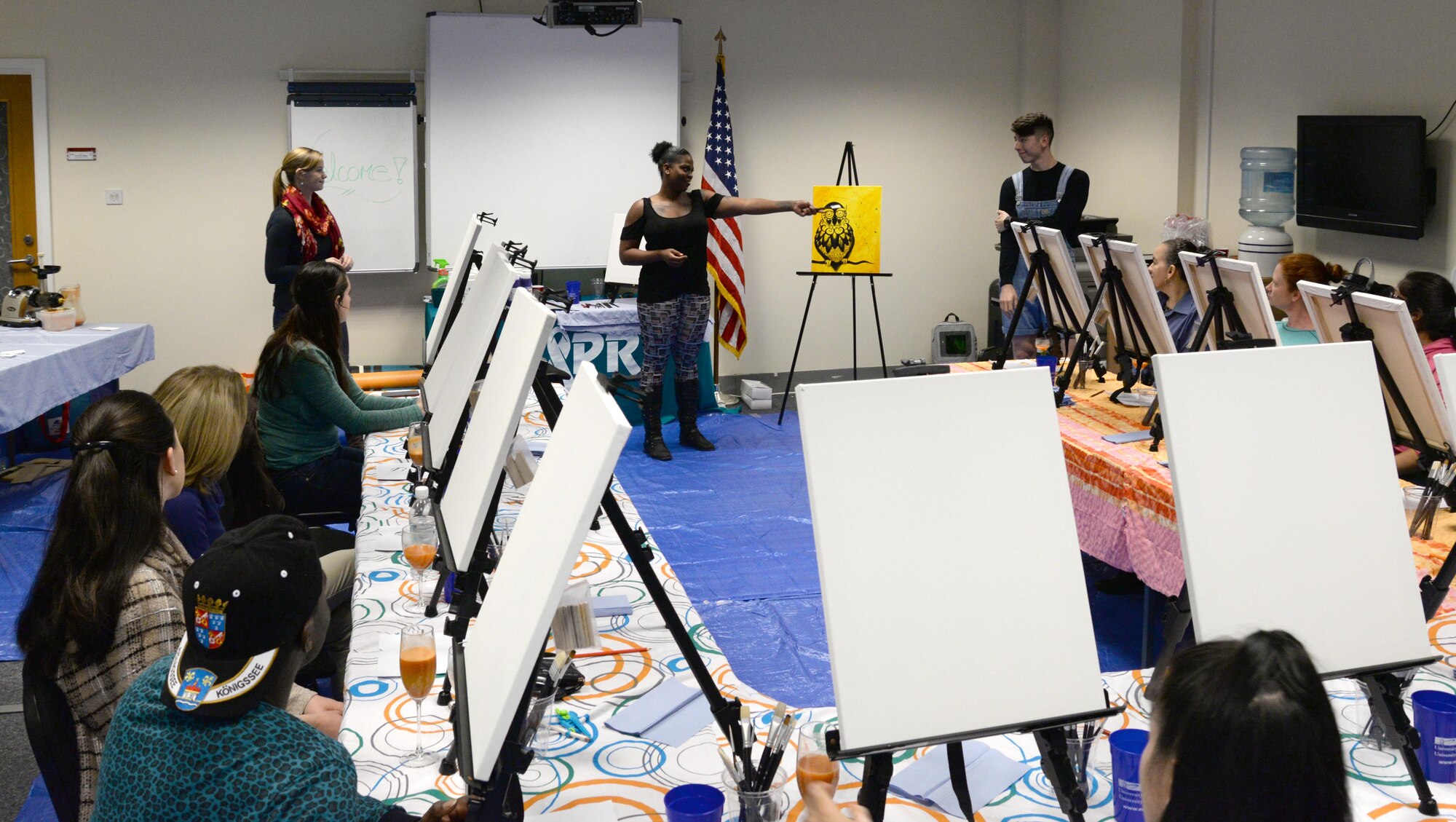 U.S. Air Force Tech. Sgt. Ceji Dorty, 488th Intelligence Squadron logistic support, center, teaches a painting class, Nov. 4, 2016, at the ‘Breathe, Sip, Paint’ event on RAF Mildenhall, England. The class was organized to teach the therapeutic benefits of creative outlets, such as painting. Guests were talked through a breathing exercise to start the class and set the tone for the evening. (U.S. Air Force photo by Senior Airman Justine Rho)