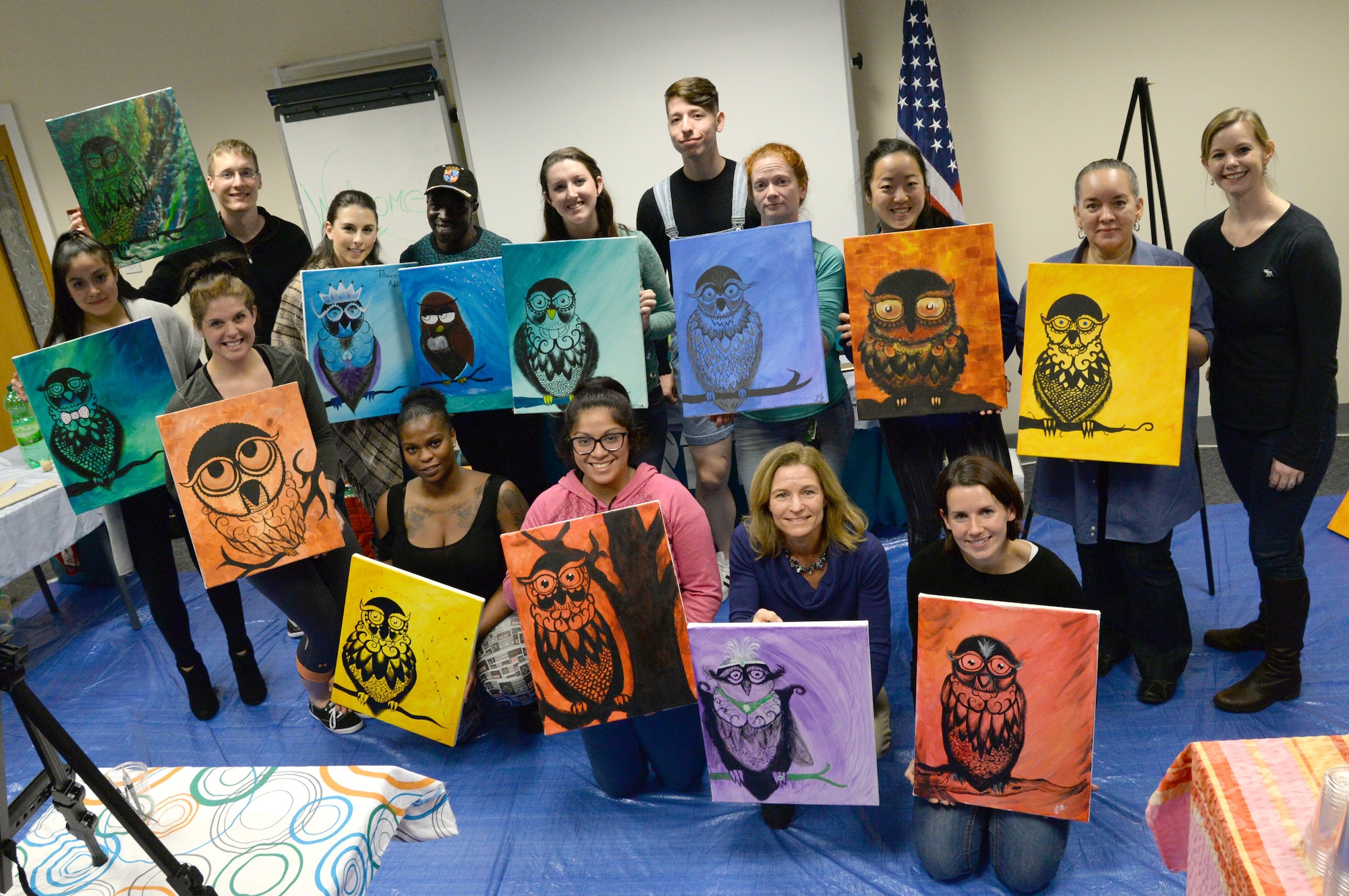 Attendees of the “Breathe, Sip, Paint’ event pose for a group photograph with their paintings Nov. 4, 2016, on RAF Mildenhall. The Center for Character and Culture organized the event to promote a stress-free creative environment and teach holistic means of resiliency. (U.S. Air Force photo by Col. John Howard)