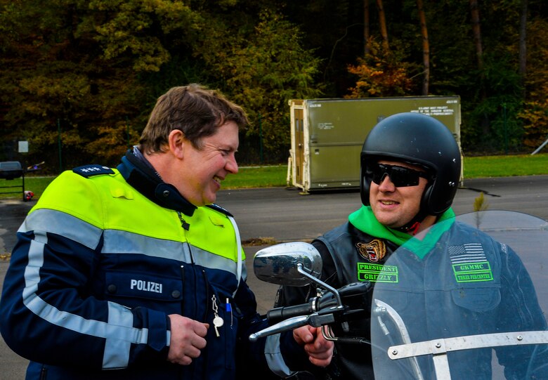Erik Hippchen, chief of the Polizei Lauterecken office, left, speaks with Tech. Sgt. Jeremy Hunt, 721st Aircraft Maintenance Squadron flightline expediter and Green Knights Military Motorcycle Club Chapter 29 president, during a motorcycle safety rodeo at Kapaun Air Station, Germany, Nov. 4, 2016. KMC RiderCoaches learned various safety maneuvers from Polizei, such as high-speed evasions, for the purpose of passing them on to other KMC motorcyclists. (U.S. Air Force photo by Airman 1st Class Joshua Magbanua)