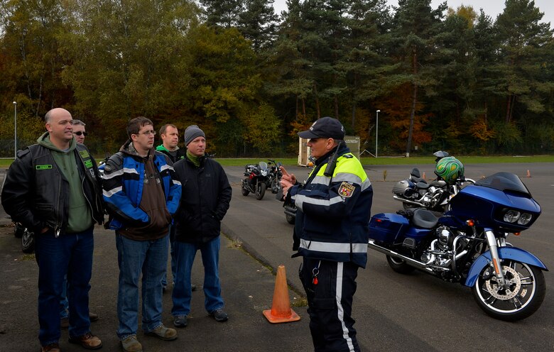 Wolfgang Hanker, chief of the Kaiserslautern Speed Control Unit, explains various motorcycle safety maneuvers to Kaiserslautern Military Community motorcyclists during a safety rally at Kapaun Air Station, Germany, Nov. 4, 2016. The 86th Airlift Wing safety office arranged for local police to come teach KMC RiderCoaches various safety maneuvers, who would then pass them along to other KMC motorcyclists. (U.S. Air Force photo by Airman 1st Class Joshua Magbanua)