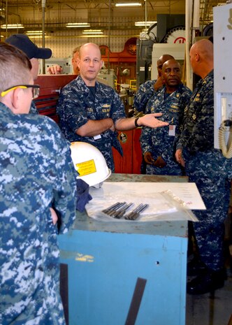 Director of Fleet Maintenance, Rear Adm. Mark Whitney (center) discusses the advantages of Computer Numerically Controlled (CNC) lathes with Senior Chief Tarah Horney (far left) at Southeast Regional Maintenance Center (SERMC) Nov. 1st. 