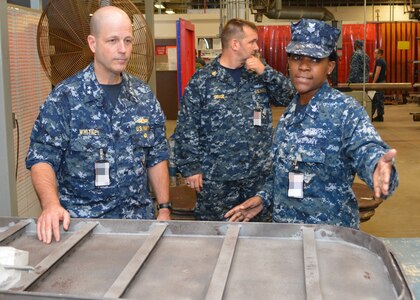 Petty Officer 1st Class Fungai Diura explains to Rear Adm. Mark Whitney, DIrector Fleet maintenance, how damaged watertight doors are repaired at Southeast Regional Maintenance Center in Jacksonville, Fla., Nov. 1st. 