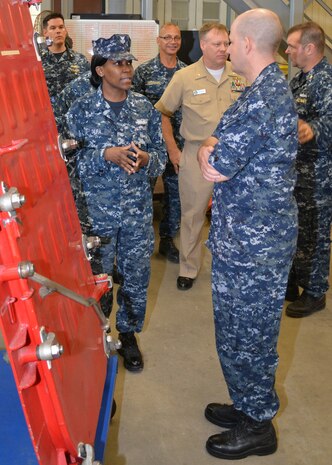 Petty Officer 1st Class Fungai Diura explains to Rear Adm. Mark Whitney, DIrector Fleet maintenance, how damaged watertight doors are repaired at Southeast Regional Maintenance Center in Jacksonville, Fla., Nov. 1st. 