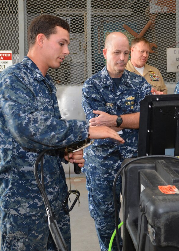 Petty Officer 3rd Class Mitchell Lafave explains the functionality of a surface-supplied camera equipment to Rear Adm. Mark Whitney at Southeast Regional Maintenance Center in Jacksonville, Fla., Nov. 1st. Rear Adm. Whitney is the Director, Fleet Maintenance under Fleet Forces Command. The camera transmits high quality video from divers working underwater which is displayed and captured digitally on the surface. 