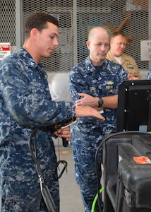 Petty Officer 3rd Class Mitchell Lafave explains the functionality of a surface-supplied camera equipment to Rear Adm. Mark Whitney at Southeast Regional Maintenance Center in Jacksonville, Fla., Nov. 1st. Rear Adm. Whitney is the Director, Fleet Maintenance under Fleet Forces Command. The camera transmits high quality video from divers working underwater which is displayed and captured digitally on the surface. 