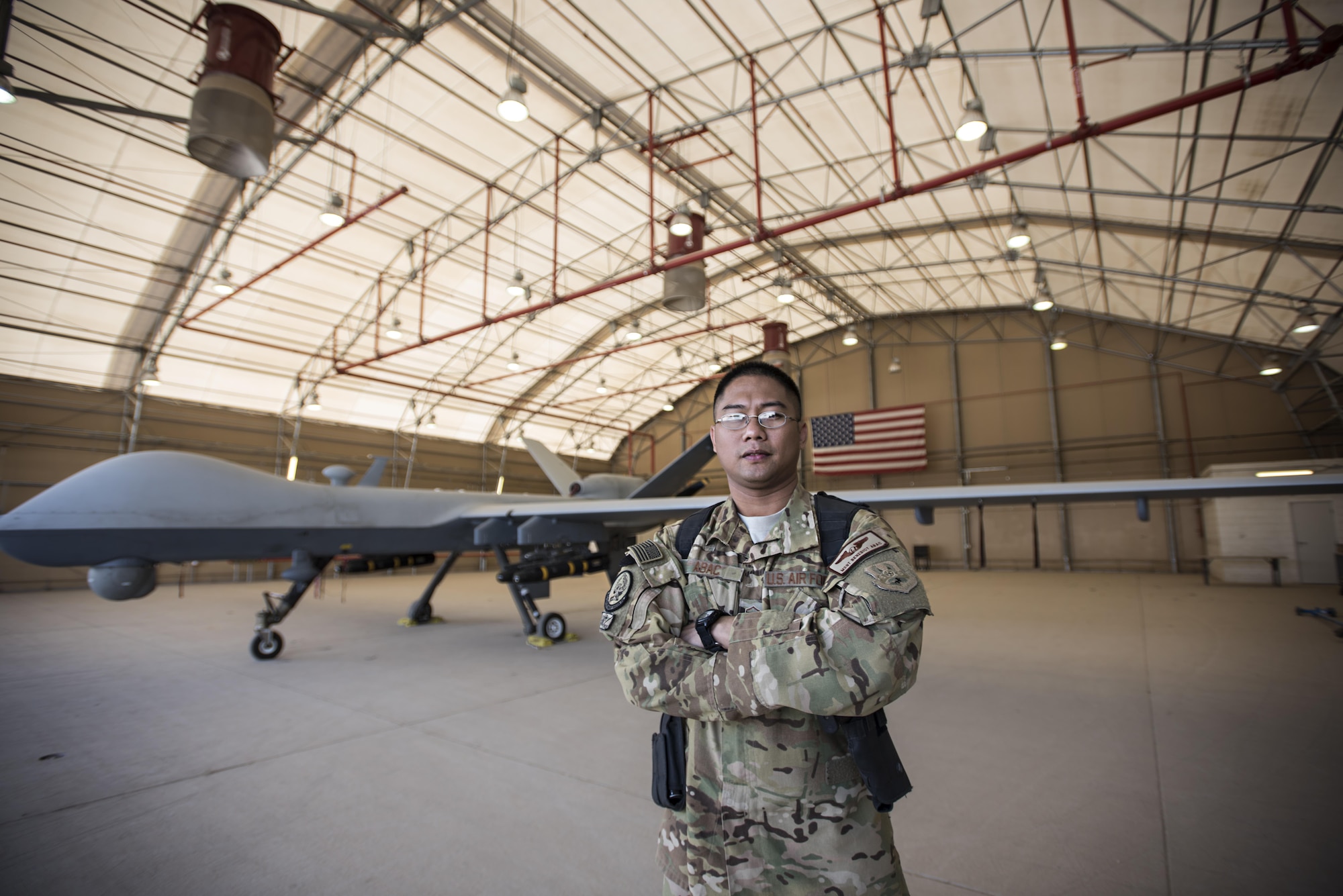 Master Sgt. Ben, 62nd Reconnaissance Squadron sensor operator, poses in front of an MQ-9 Reaper at Kandahar Airfield, Afghanistan Nov. 5, 2016. Ben is a native of the Philippines and became a U.S. citizen while serving in the U.S. Air Force. (U.S. Air Force photo by Staff Sgt. Katherine Spessa) 