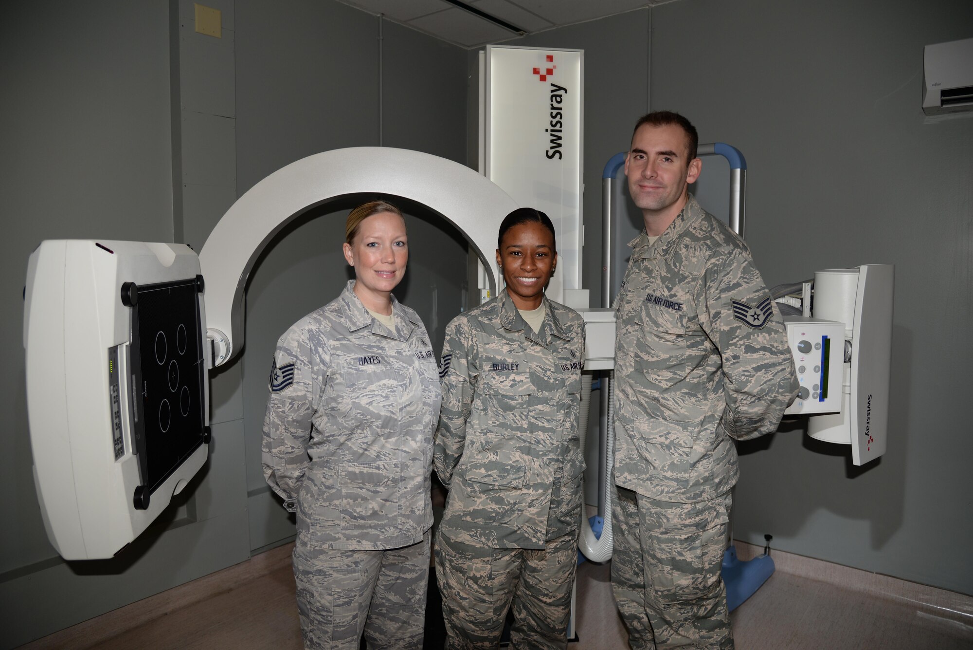 From left, Tech. Sgts. Melinda Hayes and Lachaunda Burley, and Staff Sgt. Thomas Nuckols, 436th Medical Support Squadron diagnostic imaging technicians, pose for a photograph in front of  an X-ray machine Nov. 2, 2016, at Dover Air Force Base, Del. Members of the flight support both the mission of the 436th Medical Group and the Armed Forces Medical Examiner System. (U.S. Air Force photo by Senior Airman Aaron J. Jenne) 