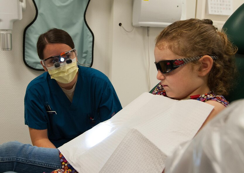 Capt. Heather Rybar, 86th Dental Squadron general dentist, talks to her patient, Emma LeNeave,  during 86th DS’s “Little Teeth, Big Smile” event at Ramstein Air Base, Germany, Nov. 5, 2016. The event invited parents to bring their children, up to 10 years old, in order to receive dental checkups and cleaning. According to the Center for Disease and Control, tooth decay is one of the most common chronic conditions of childhood in the United States. Untreated cavities can cause pain and infections that may lead to problems with eating, speaking, playing, and learning. (U.S. Air Force photo by Airman 1st Class Lane T. Plummer)