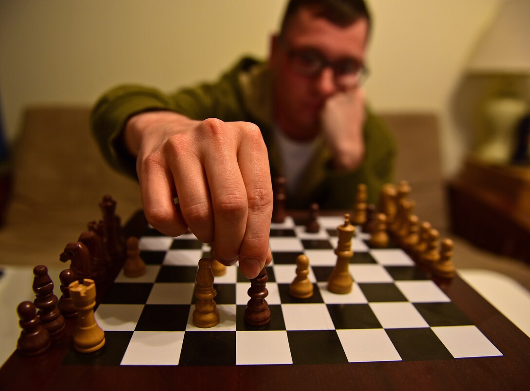 Airman 1st Class Cody Kirby, a pavement and equipment operations apprentice assigned to the 28th Civil Engineer Squadron, plays a game of chess at Ellsworth Air Force Base, S.D., Nov. 1, 2016. Chess is one of the many games Kirby plays to pass the time when the weather keeps him indoors. (U.S. Air Force photo by Airman 1st Class James L. Miller)