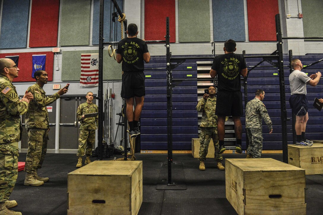 German Armed Forces Badge for military Proficiency proctors evaluate U.S. Air Force Airmen, U.S. Army Soldiers and U.S. Navy Sailors performing a flexed-arm hang during the GAFPB at Joint Base Langley-Eustis, Va., Nov. 1, 2016.  The GAFPB flexed-arm hang is just one of three events that make up the basic fitness test; a five second hold is the minimum requirement to pass.  (U.S. Air Force photo/Tech Sgt. Daylena S. Ricks)