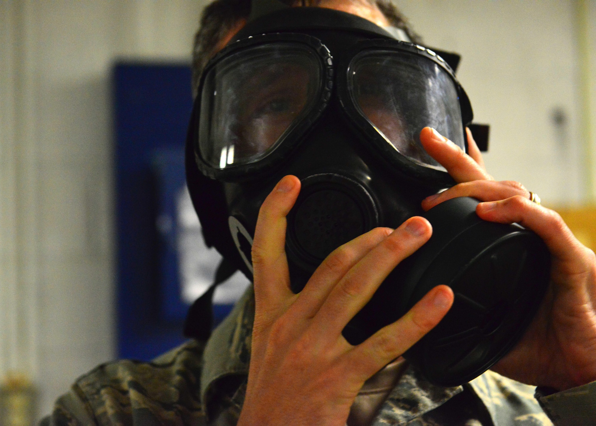 U.S. Air Force Tech. Sgt. Christopher Stahl, Air Combat Command, Heritage of America Band bassoonist, dons a gas mask and checks seal during the German Armed Forces Badge for military Proficiency event at Joint Base Langley-Eustis, Va., Nov. 2, 2016.  The GAFPB includes a pass or fail nuclear, biological, chemical evaluation of donning a protective mask within nine seconds.  (U.S. Air Force photo/Tech Sgt. Daylena S. Ricks)