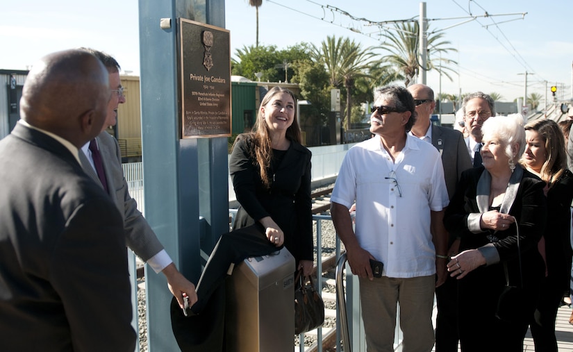Hannah Adams, center, the great-niece of Pvt. Joe Gandara, helps unveil a plaque at the Santa Monica 26th Street/Bergamot train station dedicated to her great-uncle Nov. 4, along with other Gandara family members, Santa Monica Mayor Tony Vazquez, and Los Angeles County Metropolitan Transportation Authority Chief Executive Officer Phillip Washington. Gandara, killed in action in WWII, was awarded the Medal of Honor in 2014 as part of the Valor 24 program. (U.S. Army Photo by Sgt. 1st Class Alexandra Hays, 79th Sustainment Support Command).