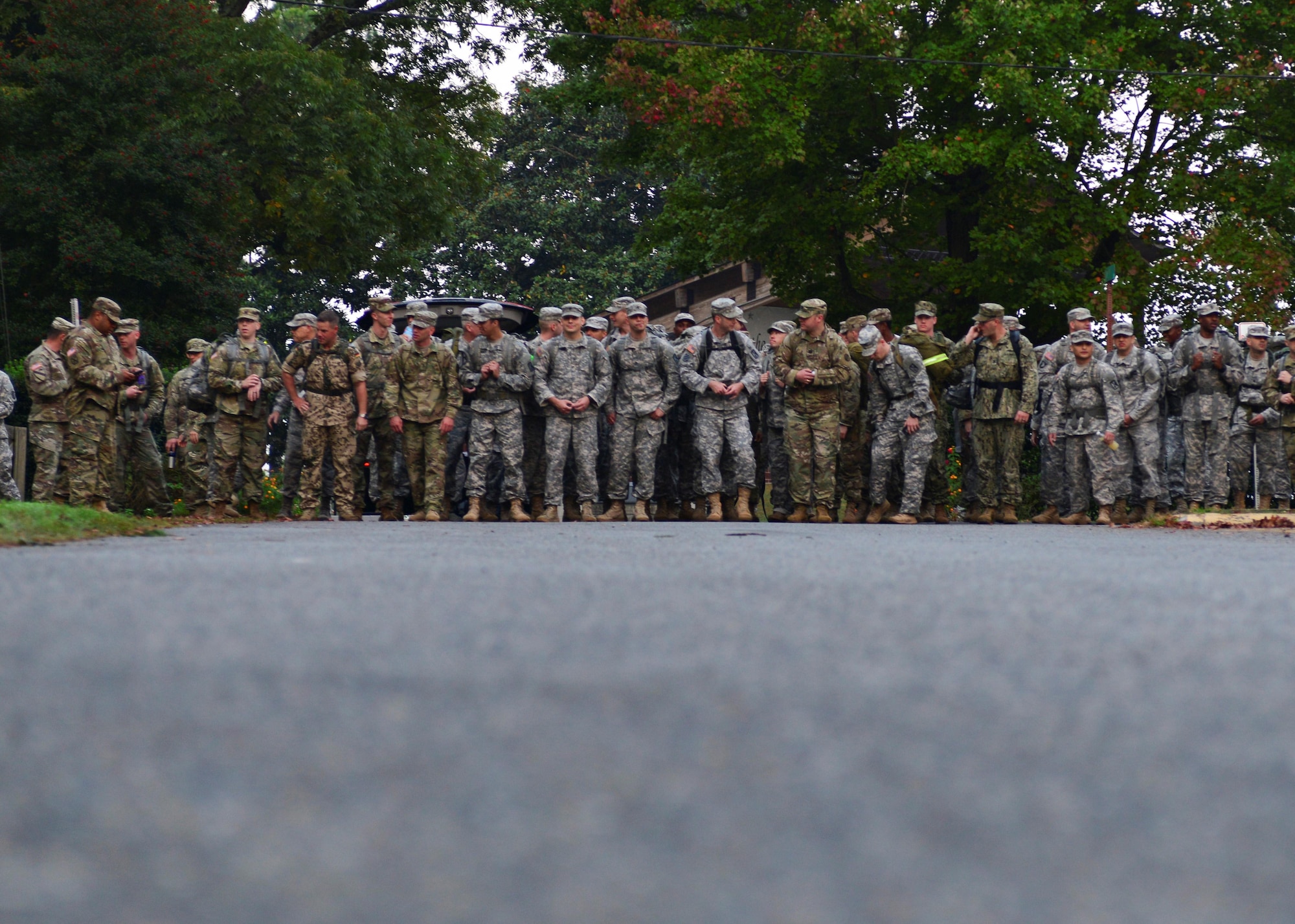 U.S. Air Force Airmen, U.S. Army Soldiers, U.S. Navy Sailors put on their rucks for the road march during the German Armed Forces Badge for military Proficiency event at Joint Base Langley-Eustis, Va., Nov. 3, 2016.  The GAFPB road march is based on completion time and distance.  To earn gold in this event the member must march 12 kilometers within 120 minutes, silver, nine kilometer within 90 minutes, bronze, six kilometers within 60 minutes. (U.S. Air Force photo/Tech. Sgt. Katherine Ward)