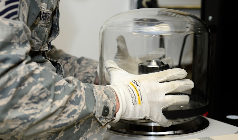 U.S. Air Force Tech. Sgt. Jonathon Harris, 1st Maintenance Squadron quality assurance manager, secures a bell jar onto the absolute pressure calibration system at Joint Base Langley-Eustis, Va., Nov. 3, 2016. The system provides a standardize pressure to calibrate equipment to, such as tires or medical supplies. (U.S. Air Force photo by Airman 1st Class Kaylee Dubois)