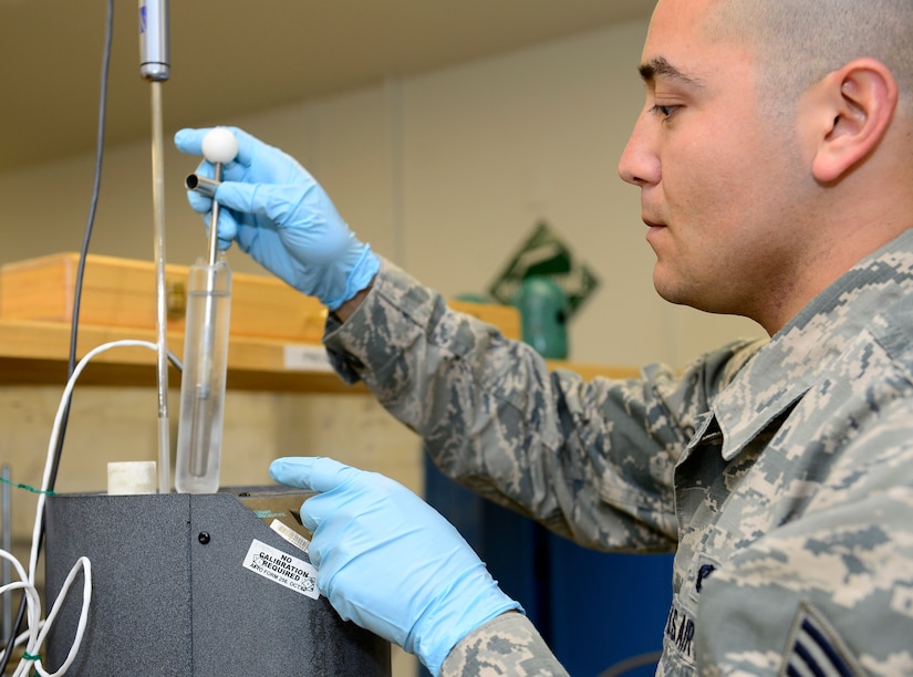 U.S. Air Force Senior Airman Ruben Mejia, 1st Maintenance Squadron precision measurement equipment laboratory technician, checks the state of water with a temperature calibration system at Joint Base Langley-Eustis, Va., Nov. 3, 2016. Meteorology, parachutes, and jet engines all benefit from the temperature calibration system which provides a reference for what temperature equipment can be used in successfully. (U.S. Air Force photo by Airman 1st Class Kaylee Dubois)