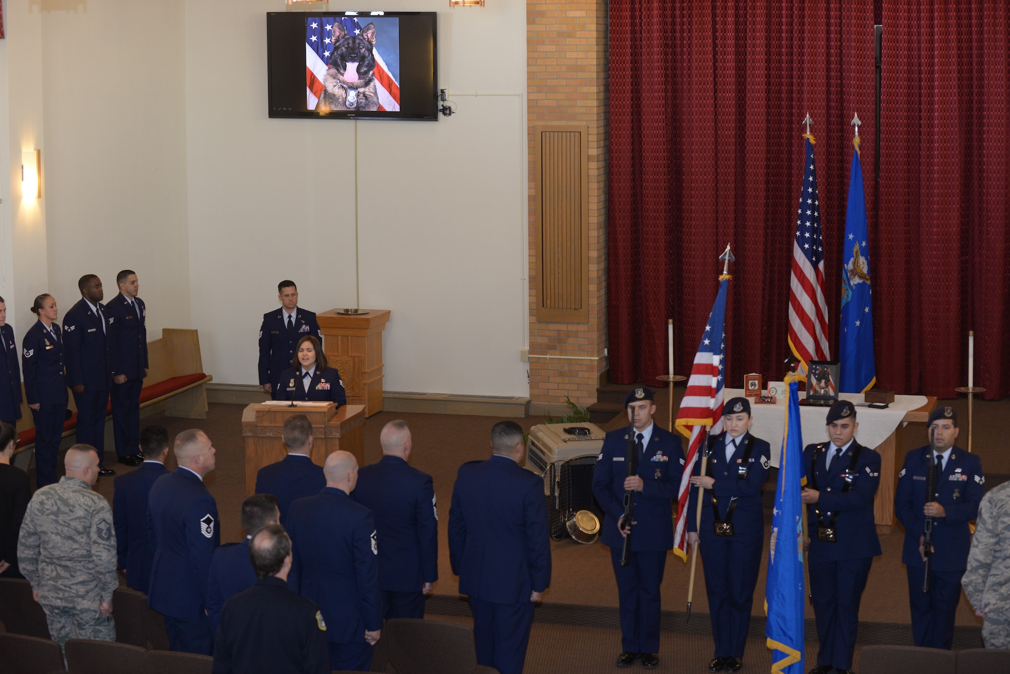 Airmen of the 28th Security Forces Squadron pay their respects to the fallen military working dog, Xarius, in the Freedom Chapel at Ellsworth Air Force Base, S.D., Nov. 4, 2016. When a military working dog falls in the line of duty the unit honors the fallen defender with a full retirement ceremony in memory of their service. (U.S. Air Force photo by Airman 1st Class Donald C. Knechtel)