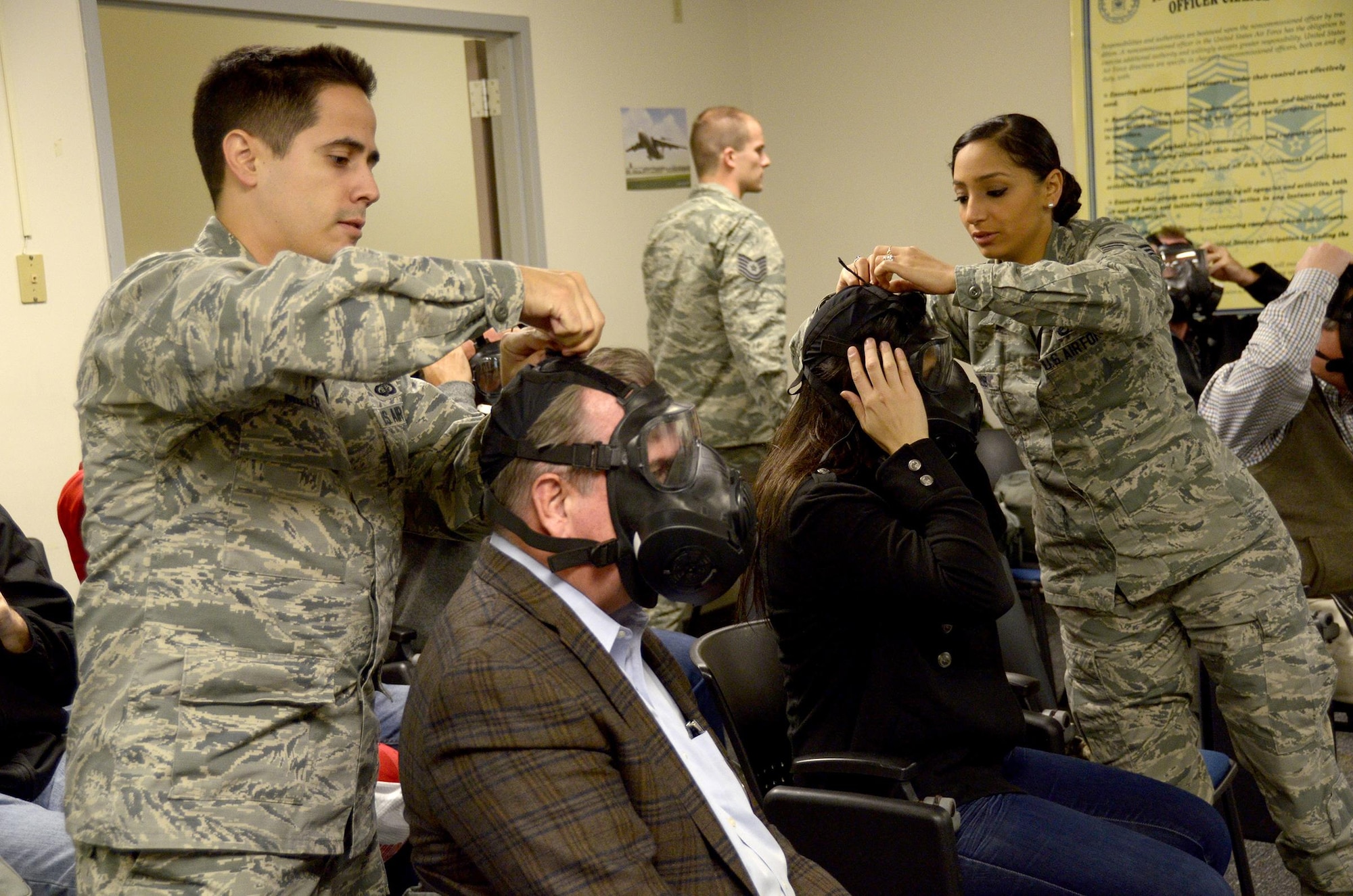 Maj. Jason Miller, 445th Force Support Squadron commander, and Senior Airman Jowanda Ayoub, 445th Maintenance Group maintenance scheduler, help their employers don chemical warfare masks during the civil engineer demonstration that was part of the 445th Airlift Wing Employers Day Nov. 5, 2016. Approximately 70 employers and 35 reservists enjoyed breakfast and lunch, received a C-17 Globemaster III flight, participated in tours and demonstrations of the different jobs and training that their Air Force Reserve employees do when performing military service. The employers also received information about the Employer Support of the Guard and Reserve program. (U.S. Air Force photo/Staff Sgt. Joel McCullough)