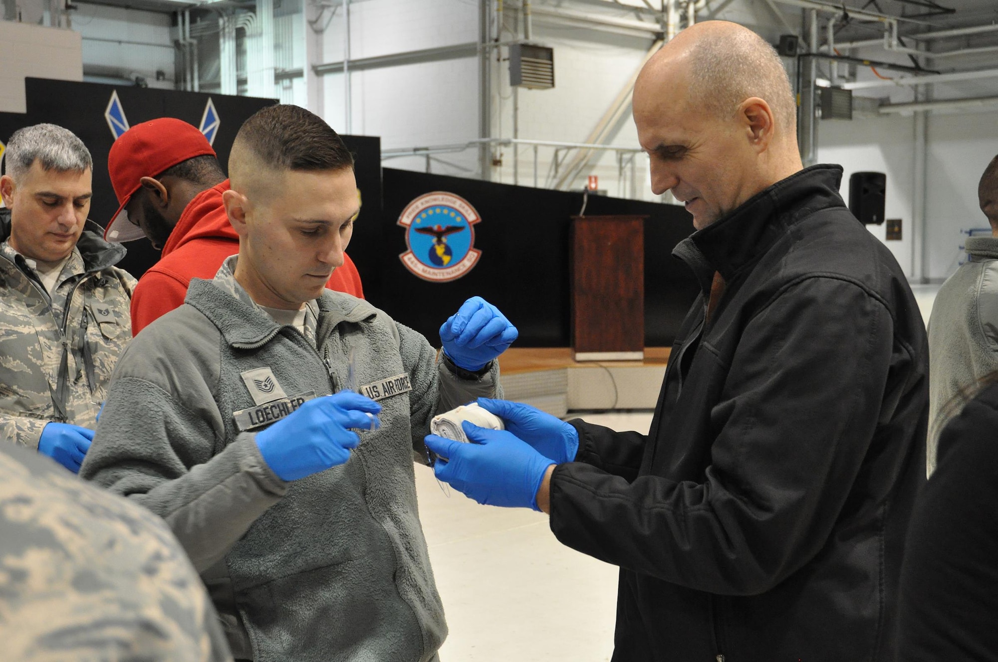Tech. Sgt. Zachary Loechler, 87th Aerial Port Squadron air transportation craftsman, and his employer, Gerald Johnson, claims litigation manager for Safe Auto Insurance Company, practice suturing during a demonstration provided by the 445th Aerospace Medicine Squadron as part of the 445th Airlift Wing Employers Day Nov. 5, 2016. Approximately 70 employers and 35 reservists enjoyed breakfast and lunch, received a wing mission briefing, received a C-17 Globemaster III flight, participated in tours and demonstrations of the different jobs and training that their Air Force Reserve employees do when performing military service. The employers also received information about the Employer Support of the Guard and Reserve program. (U.S. Air Force photo/Staff Sgt. Rachel Ingram)