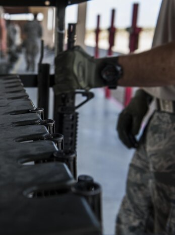 Staff Sgt. Kade Vincent, 99th Security Forces Squadron combat arms instructor, removes an M4 carbine from a gun rack during a Combat Arms Training and Maintenance M4 carbine training class on Nellis Air Force Base, Nev., Oct. 25, 2016. CATM teaches the proper use of the weapons Airmen use while deployed, permanently changing station, or fulfilling annual requirements. (U.S. Air Force photo by Airman 1st Class Kevin Tanenbaum/Released)