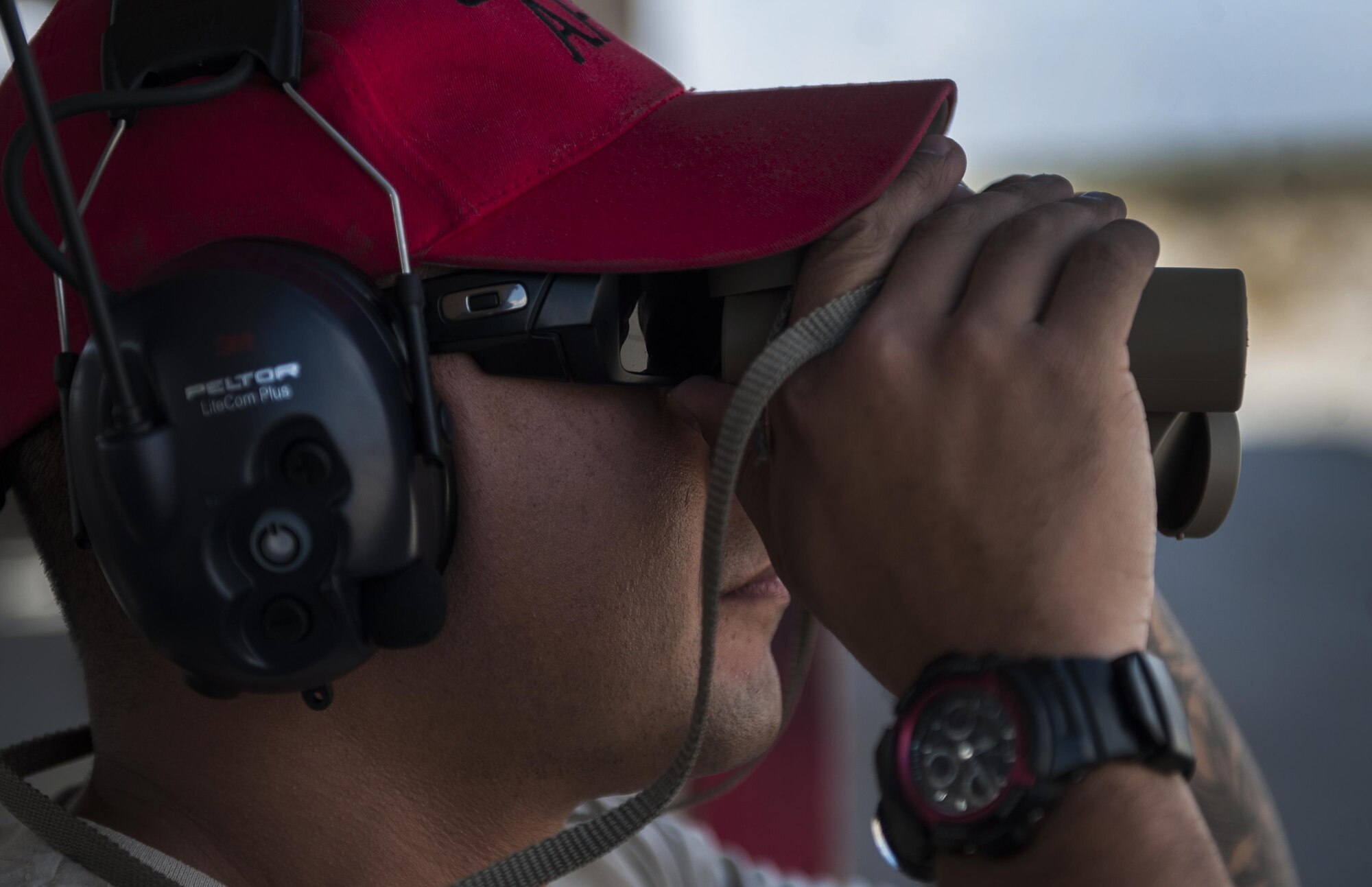 Staff Sgt. Jorge Lopez, a 99th Security Forces Squadron combat arms instructor, uses binoculars to view a target during a Combat Arms Training and Maintenance M4 carbine class on Nellis Air Force Base, Nev., Oct. 25, 2016. CATM provides Airmen with the skills and confidence that will serve them throughout their deployment and beyond. (U.S. Air Force photo by Airman 1st Class Kevin Tanenbaum/Released)