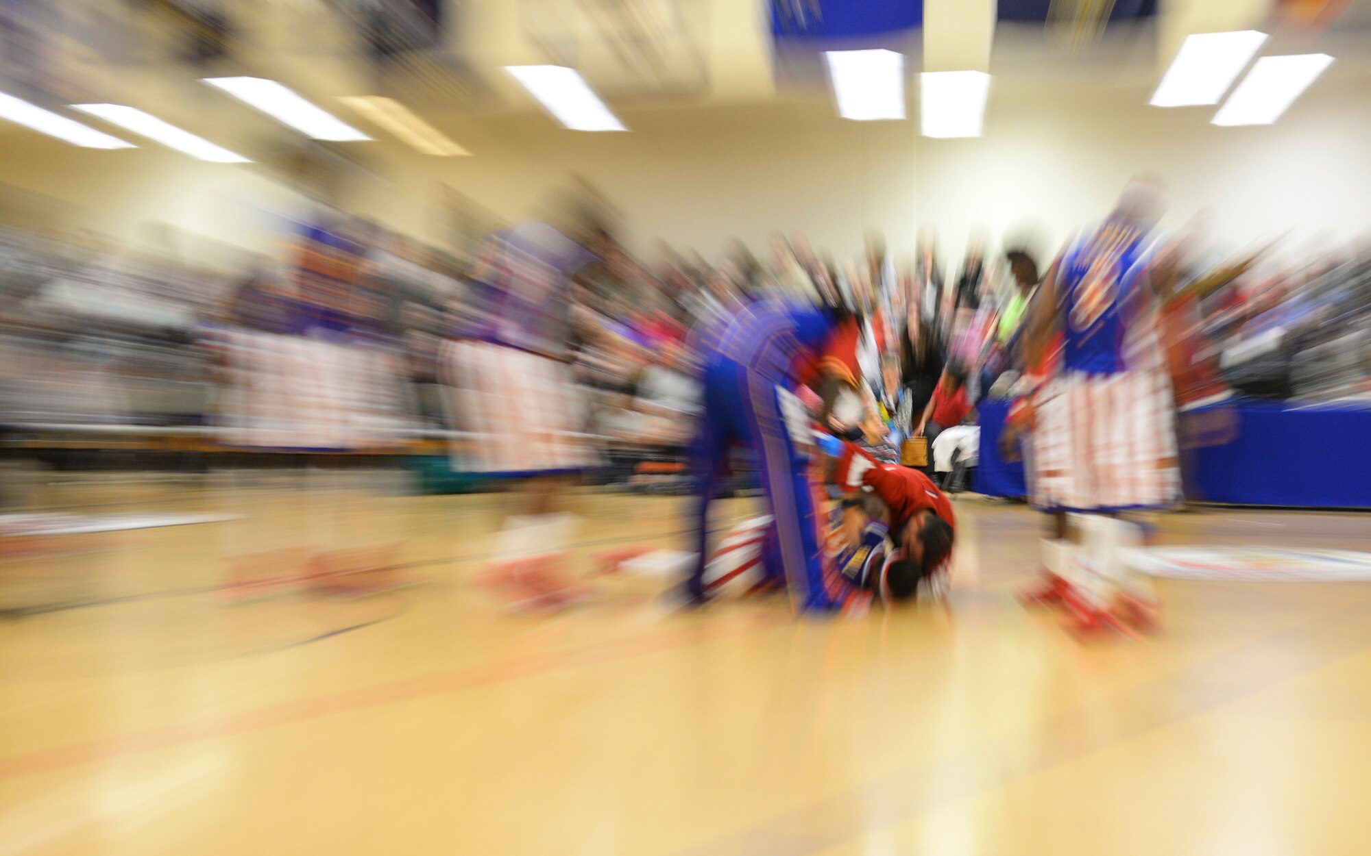 The Harlem Globetrotters gather around forward Bull after he was injured Nov. 4, 2016, at the Hardstand Fitness Center on RAF Mildenhall, England. The injury was part of the show and Bull returned later in the game to help the team win the game. (U.S. Air Force photo by Staff Sgt. Micaiah Anthony)