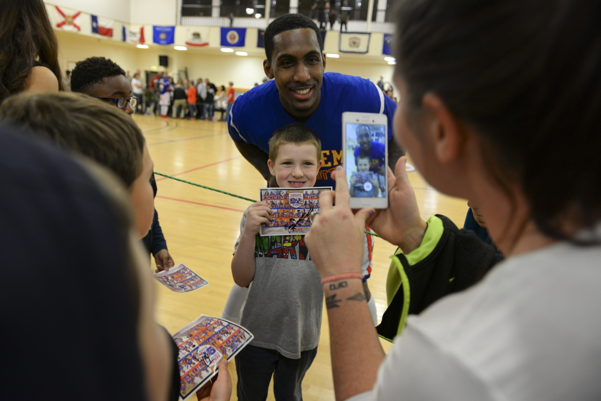 Harlem Globetrotters forward, Bull, poses for a photo with a fan after the show Nov. 4, 2016, at the Hardstand Fitness Center on RAF Mildenhall, England. The Harlem Globetrotters have been labeled goodwill ambassadors for their local and global community involvement and history of breaking down barriers. (U.S. Air Force photo by Staff Sgt. Micaiah Anthony)