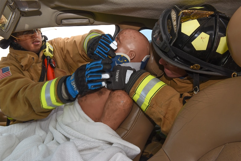 PETERSON AIR FORCE BASE, Colo. – Firefighters from the Peterson Air Force Base Fire Department stabilize a simulated victim’s neck during a driving under the influence car accident scenario for the Condor Crest exercise at Peterson AFB., Colo., Nov. 1, 2016. The firefighters had to cut the car door open with the Jaws of Life in order to reach the victim. (U.S. Air Force photo by Philip Carter)