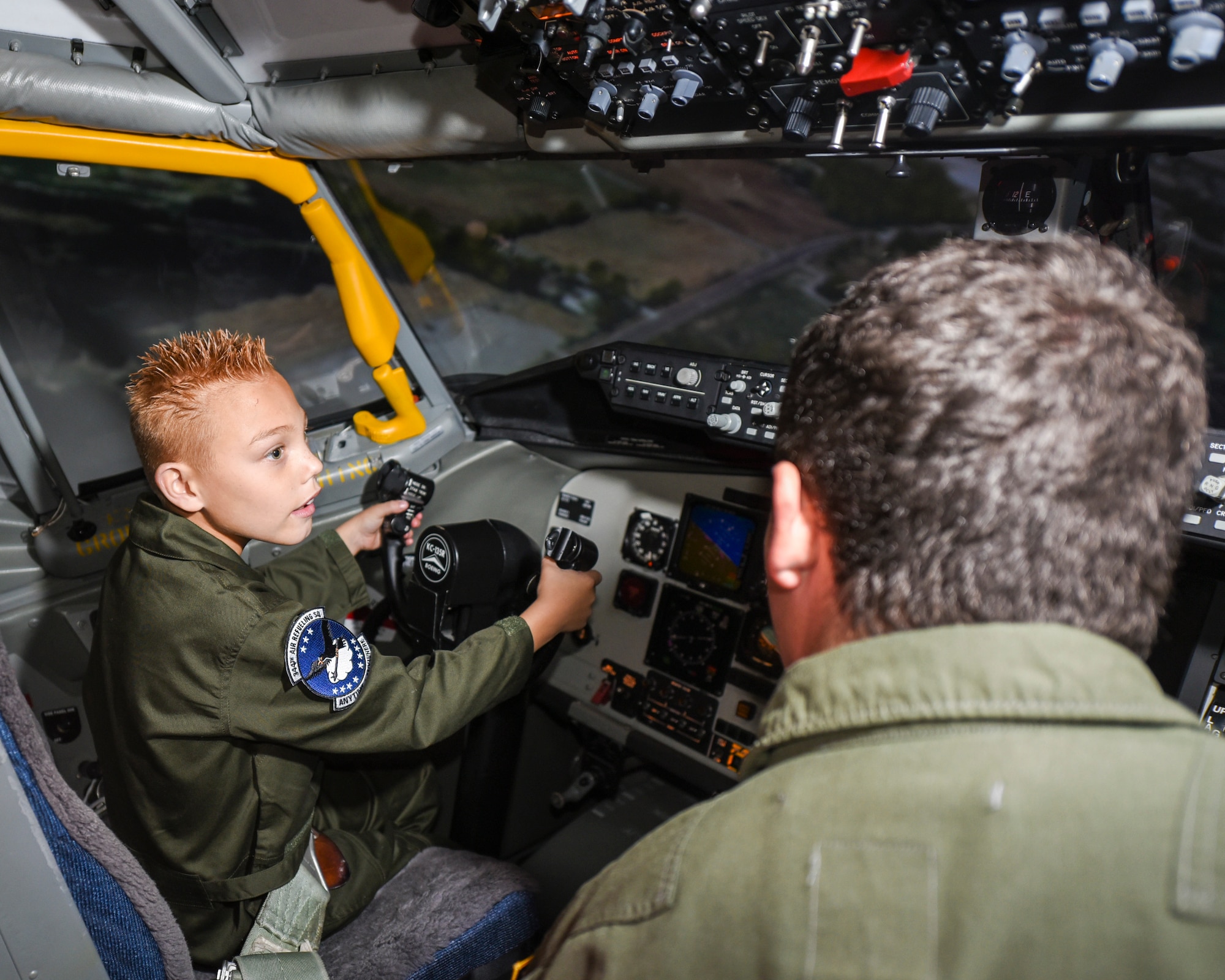 Tyson Gray, 10 years old, sits in the cockpit of KC-135 Stratotanker simulator while 1st Lt. Carson Fugal, 344th Air Refueling Squadron co-pilot and “Pilot for a Day” coordinator, observes Nov. 8, 2016, at McConnell Air Force Base, Kan. The 344th ARS welcomed Tyson to the base as part of the first “Pilot for a Day” event since 2011. The squadron now plans to host this event twice a year. (U.S. Air Force photo/Senior Airman Christopher Thornbury)