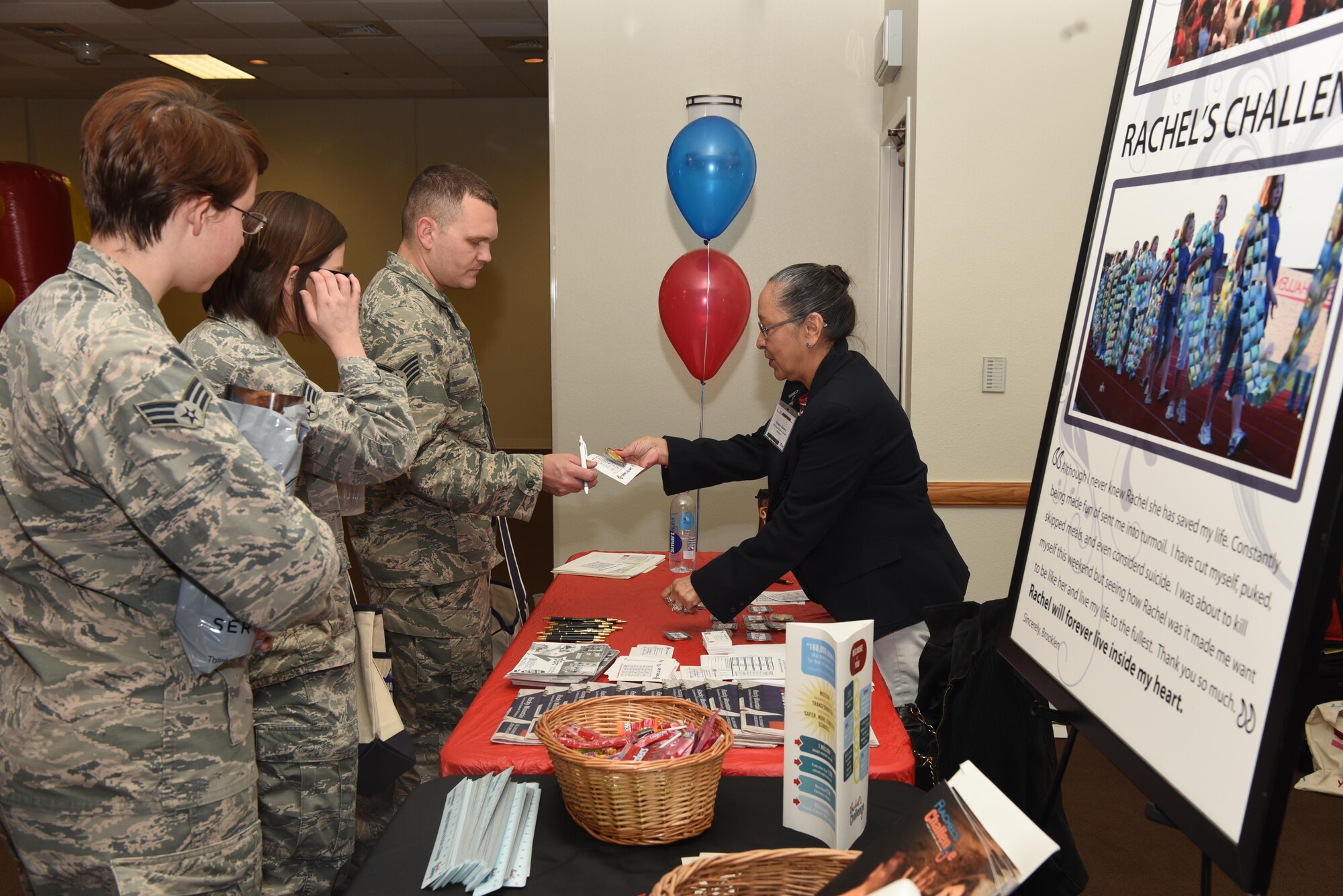 A Combined Federal Campaign representative hands out coins during the kick-off event at F.E. Warren Air Force Base, Wyo., Nov. 7, 2016. Participants had to visit at least five charity tables to redeem a CFC coin. (U.S. Air Force photo by Airman 1st Class Breanna Carter)