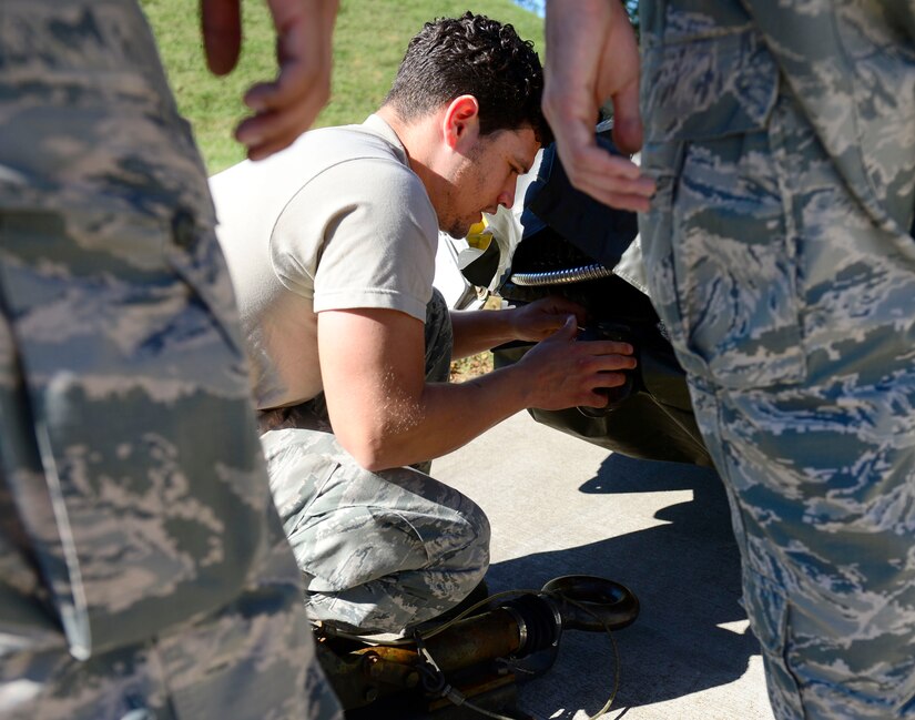 U.S. Air Force Staff Sgt. David Quinones, 1st Maintenance Squadron munitions flight supervisor, helps his team unlatch a trailer of ammunitions at Joint Base Langley-Eustis, Va., Oct. 21, 2016. Along with ammunition, munitions flight technicians are also responsible for assembling chaff and flares, which are countermeasures used by pilots to ward off enemies while in flight. (U.S. Air Force photo by Airman 1st Class Kaylee Dubois)