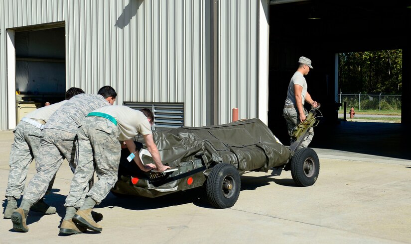 Airmen with the 1st Maintenance Squadron munitions flight haul a trailer filled with ammunitions at Joint Base Langley-Eustis, Va., Oct. 21, 2016. One completed munition can weigh up to 1,000 lbs., and each trailer can hold up to four munitions at a time. (U.S. Air Force photo by Airman 1st Class Kaylee Dubois)