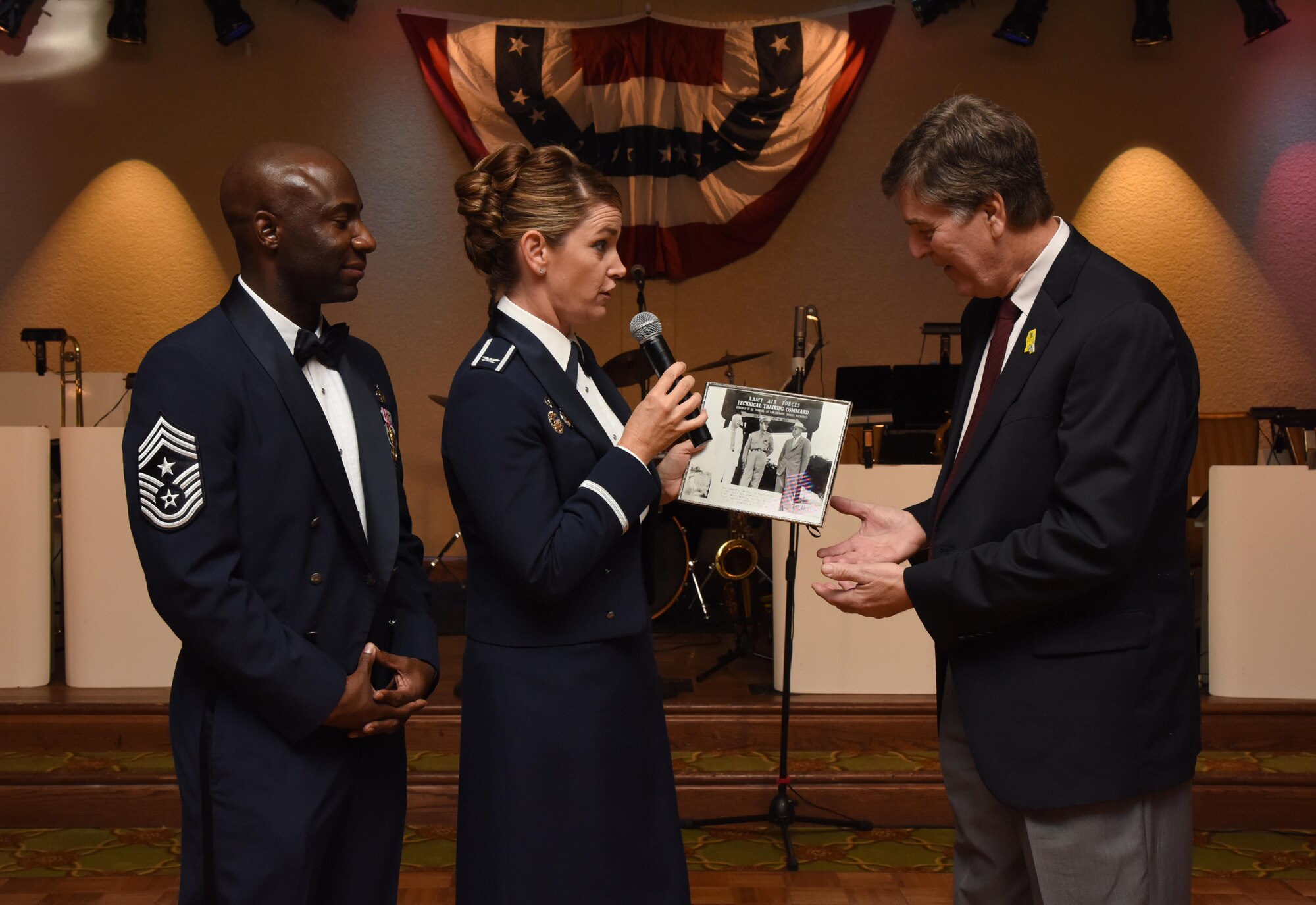 Col. Michele Edmondson, 81st Training Wing commander, and Chief Master Sgt. Vegas Clark, 81st TRW command chief, present a historical photo to Andrew Gilich, Biloxi mayor, during the installation’s 75th Anniversary Gala at the Bay Breeze Event Center Nov. 4, 2016, on Keesler Air Force Base, Miss. The celebration commemorated Keesler’s 75 years of history with historical displays, throwback trivia, musical and dance performances and recognition of family members of Lt. Samuel Keesler, Jr. (U.S. Air Force photo by Kemberly Groue/Released)