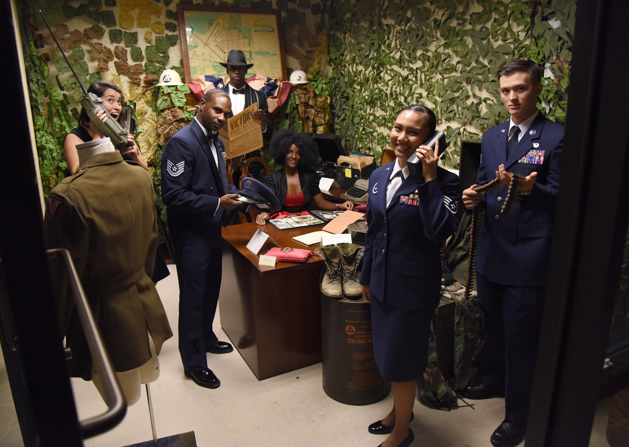 Keesler Airmen pose for a photo with military  memorabilia during the installation’s 75th Anniversary Gala at the Bay Breeze Event Center Nov. 4, 2016, on Keesler Air Force Base, Miss. The celebration commemorated Keesler’s 75 years of history with historical displays, throwback trivia, musical and dance performances and recognition of family members of Lt. Samuel Keesler, Jr. (U.S. Air Force photo by Kemberly Groue/Released)