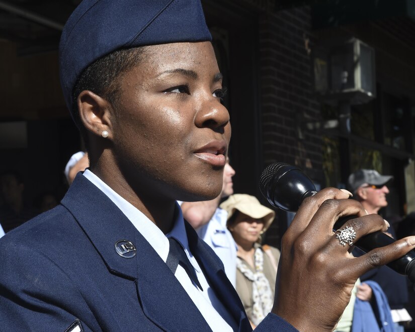 Senior Airman Kahdija Slaughter, 628th Air Base Wing broadcast journalist, sings the national anthem during the Veterans Day parade in Charleston, South Carolina, Oct. 6, 2016. During the national anthem, a C-17 Globemaster III from Joint Base Charleston – Air Base, S.C., flew over the downtown area.