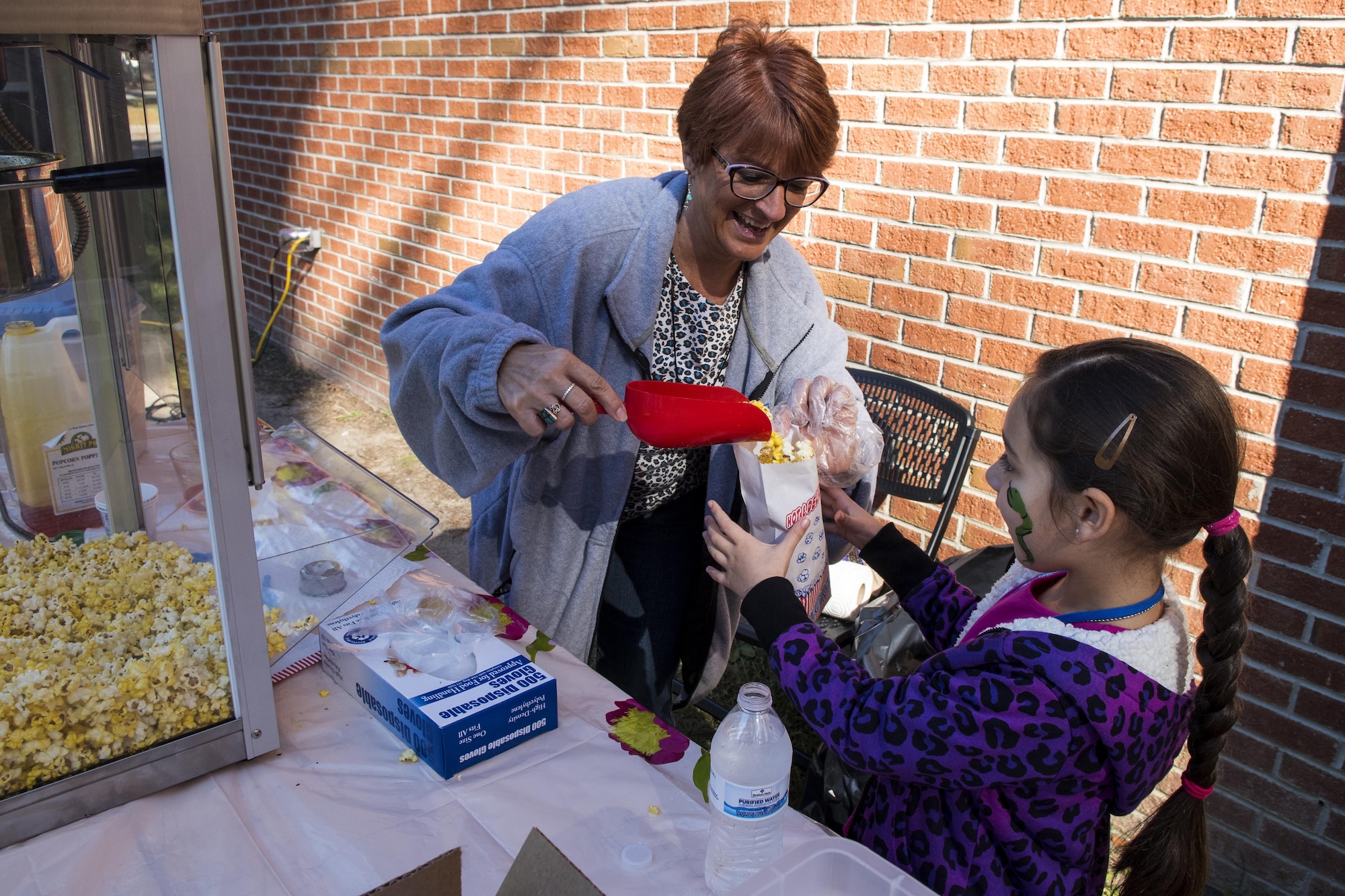 Elizabeth Smothers (left), 4th Force Support Squadron Airman and Family Readiness community readiness consultant, gives popcorn to a child during an annual Military Family Appreciation event, Nov. 5, 2016, at Seymour Johnson Air Force Base, North Carolina. More than 300 Airmen and family members received a free lunch and the opportunity to participate in multiple activities aimed at showing appreciation and providing a fun atmosphere. (U.S. Air Force photo by Airman Shawna L. Keyes)