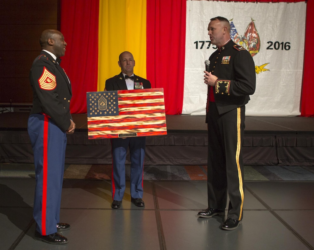 Col. John Evans (right), commanding officer, Marine Corps Security Force Regiment, and Sgt. Maj. Darby Noonan (center), sergeant major, MCSFR, present Sergeant Major of the Marine Corps Ronald Green, the guest of honor, with a hand-crafted gift as a token of appreciation at the regiment’s 241st United States Marine Corps Birthday Ball at the Virginia Beach Convention Center in Virginia Beach, Va., Nov. 4. The Marine Corps birthday ball is an annual celebration where Marines gather to honor the past, present and future of the Marine Corps with a traditional ball and cake-cutting ceremony. (Official U.S. Marine Corps photo by Sgt. Calvin Shamoon/Released)